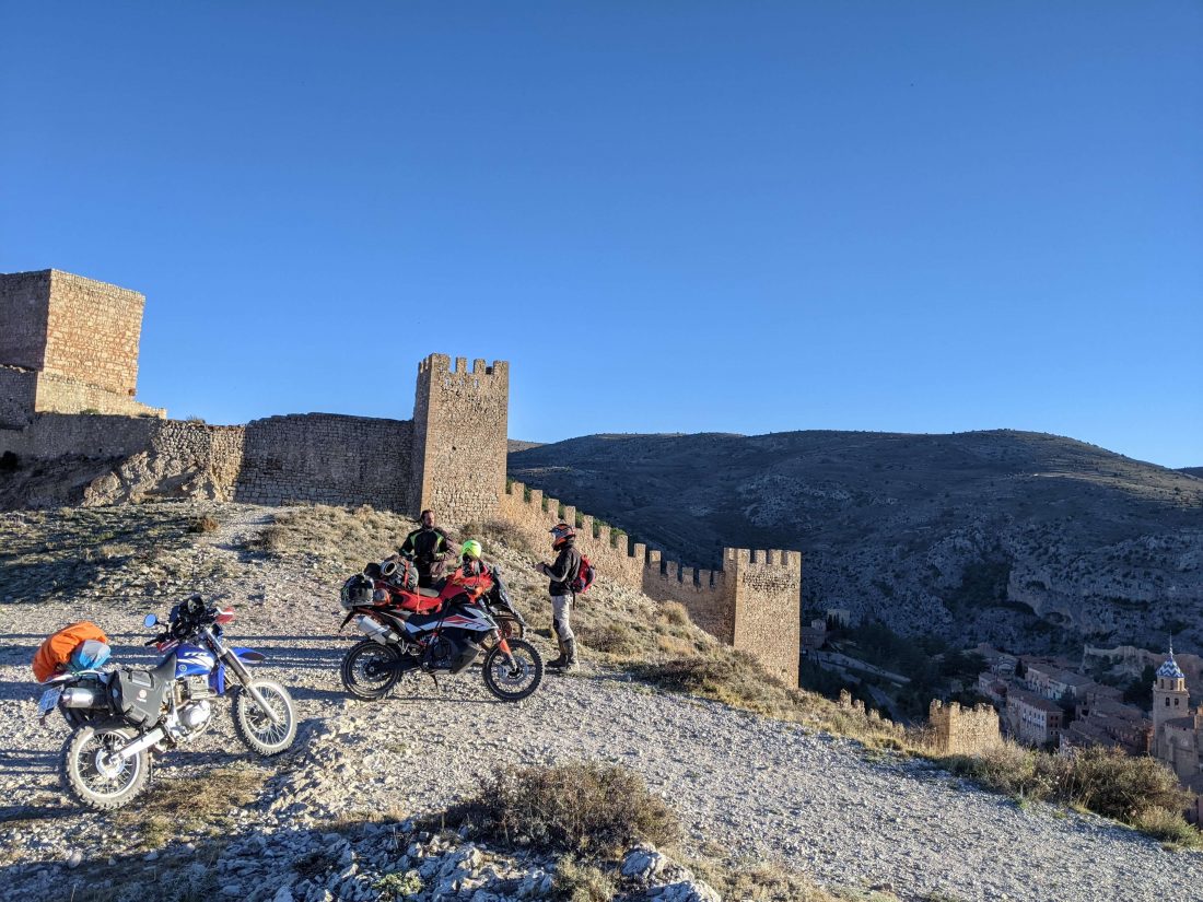 Tres motos junto a un castillo llegando a Albarracin desde la montaña