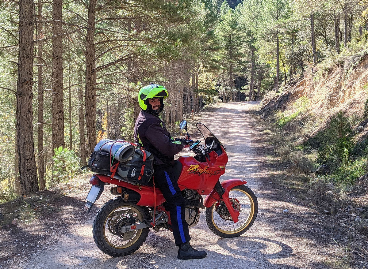 Piloto y moto Honda Dominator posando en un camino en Cuenca