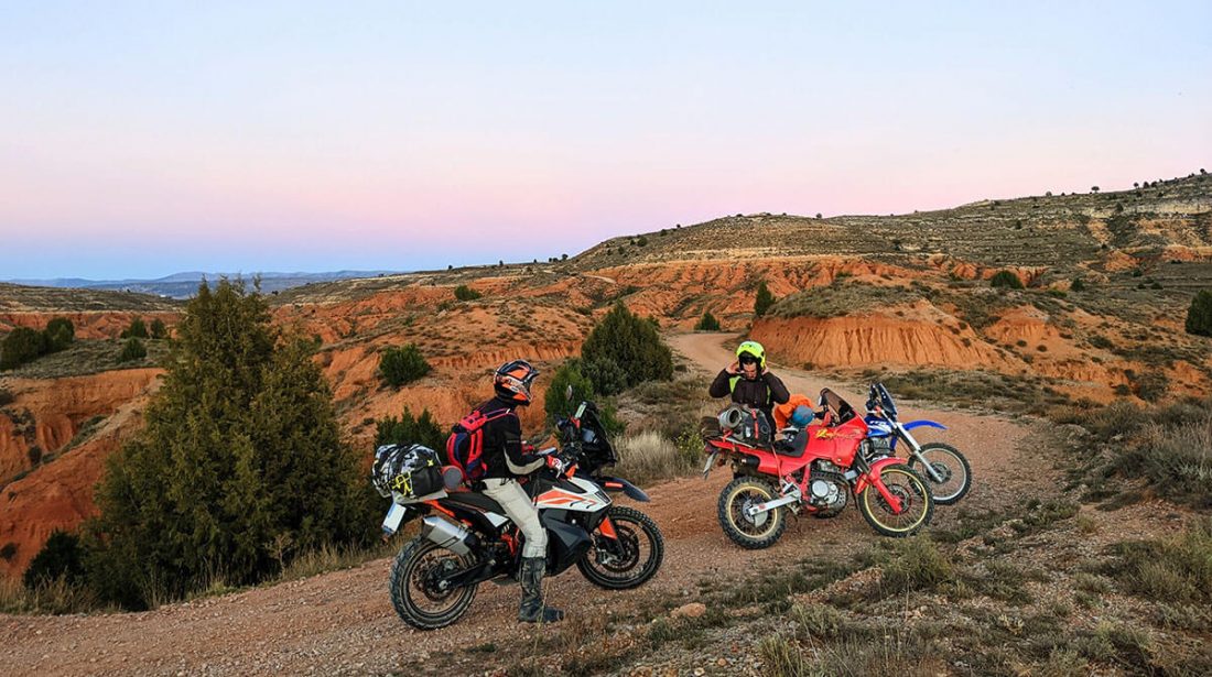 Tres motos y dos pilotos posando en un camino entre bárdenas cerca de Teruel